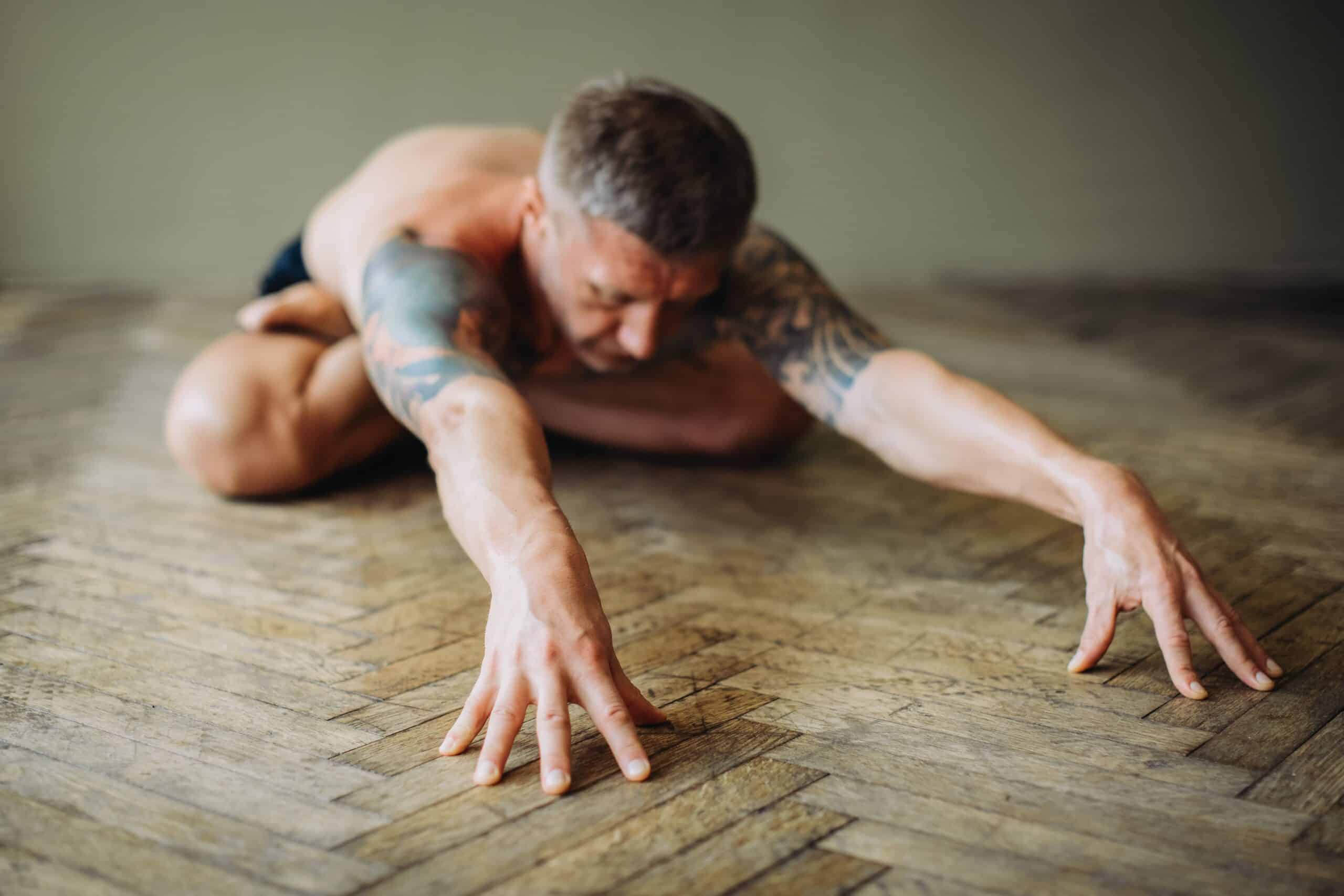 A fitness athlete practicing a restorative yoga pose on a mat for muscle recovery.