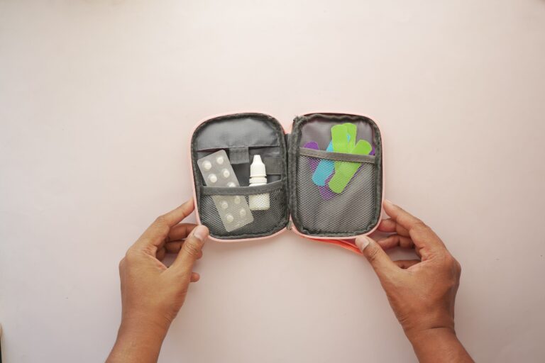 A portable TENS unit with neatly wrapped wires stored inside a clear plastic organizer container.